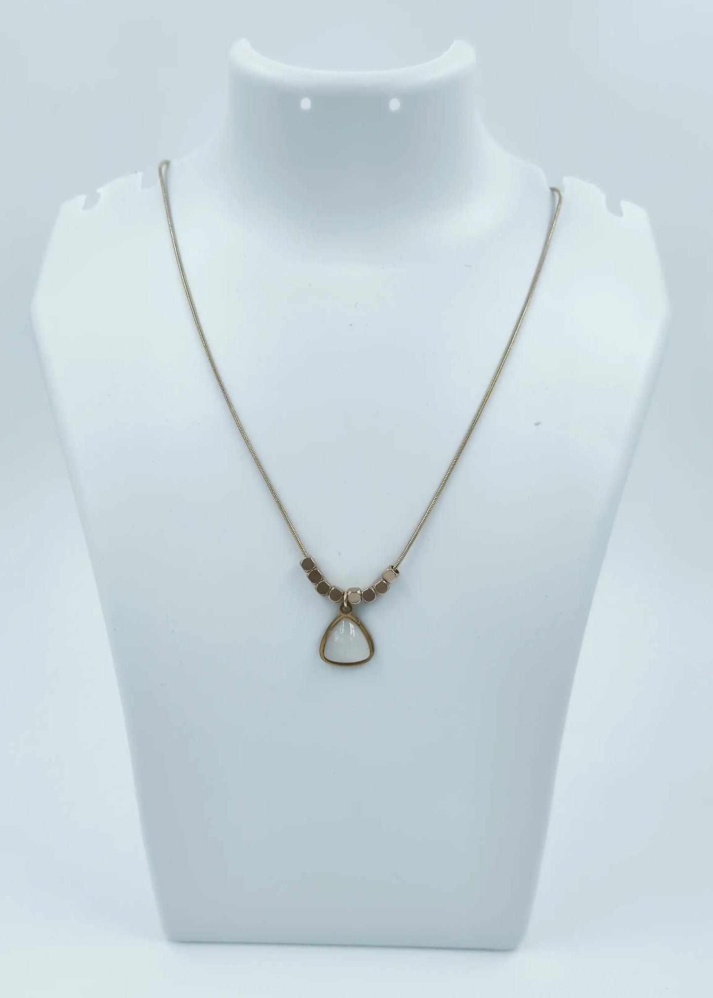 Necklace with a pendant on a mannequin bust against a white background