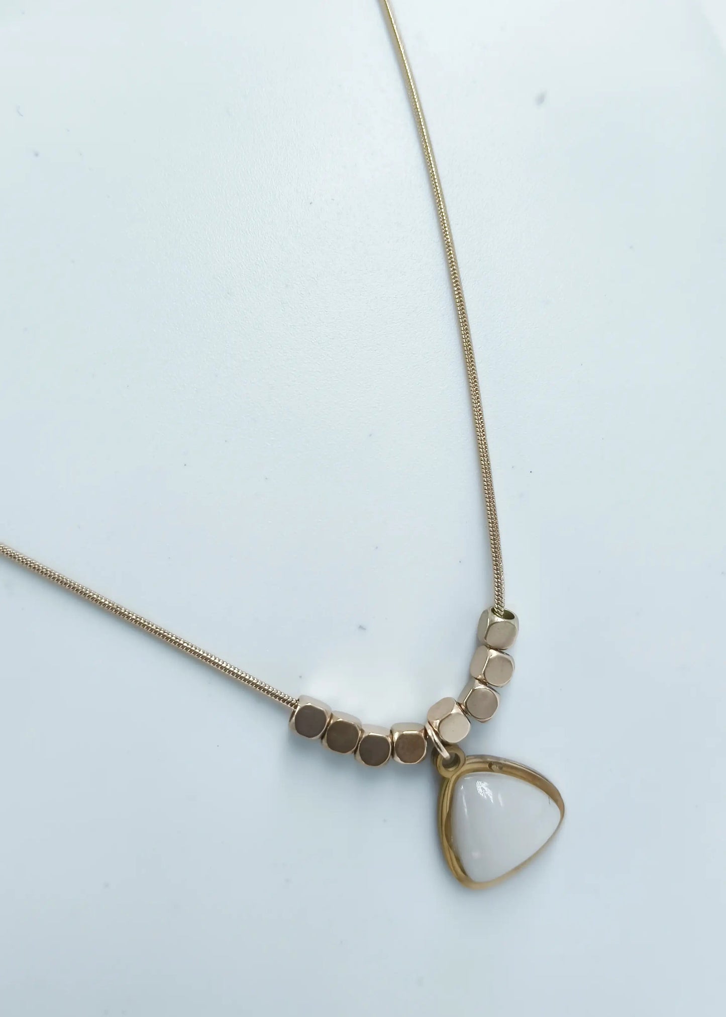 Necklace with a triangle-shaped pendant on a light background
