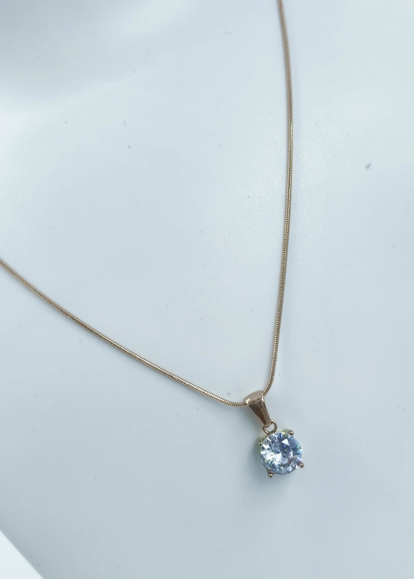 Necklace with a pendant featuring a blue gemstone on a light gray background