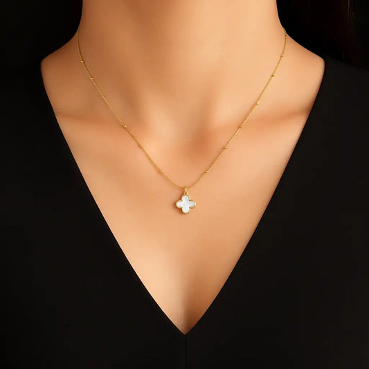 Gold necklace with a flower pendant on a mannequin against a black background