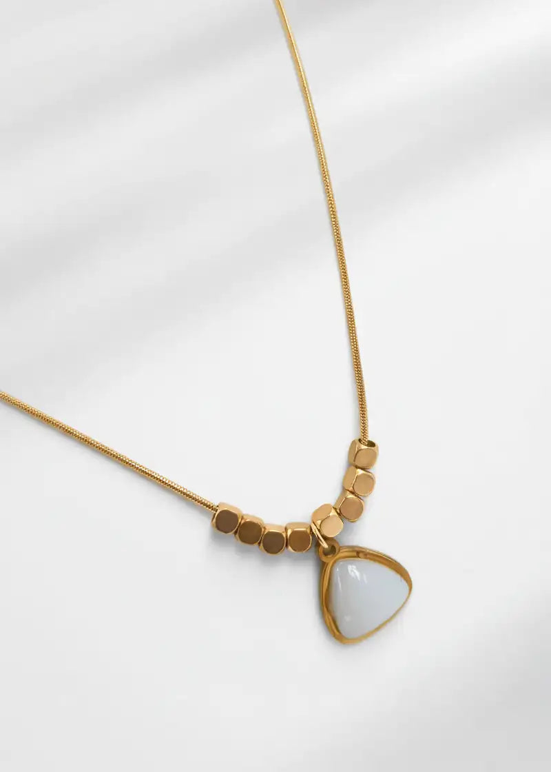 Gold necklace with a triangular pendant on a white background