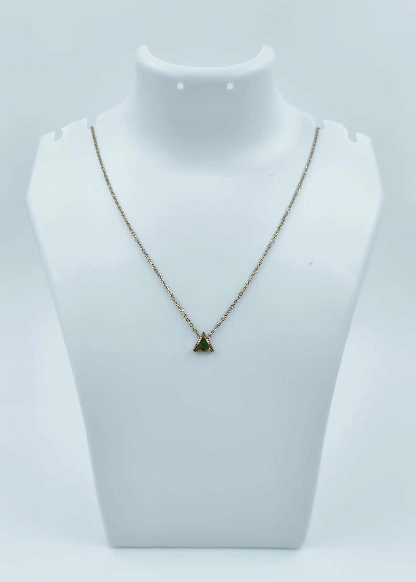 Necklace with a green pendant on a mannequin bust against a white background