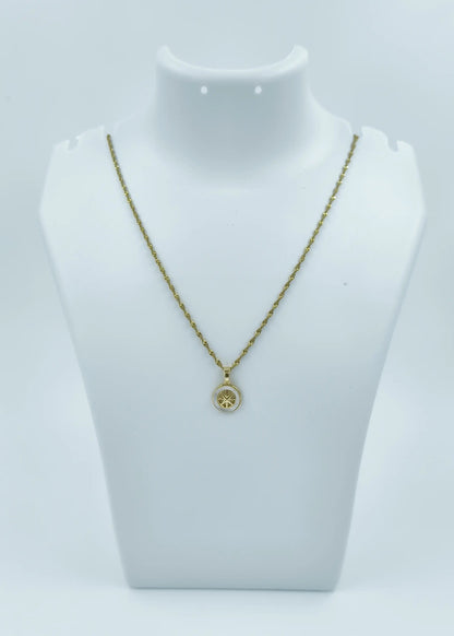 Gold necklace with a pendant on a mannequin bust against a white background