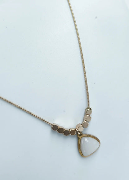 Necklace with a triangle-shaped pendant on a light background