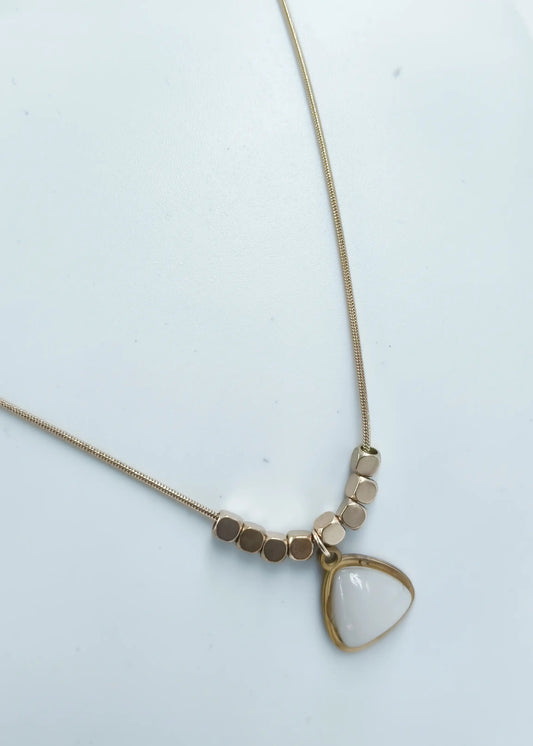 Necklace with a triangle-shaped pendant on a light background