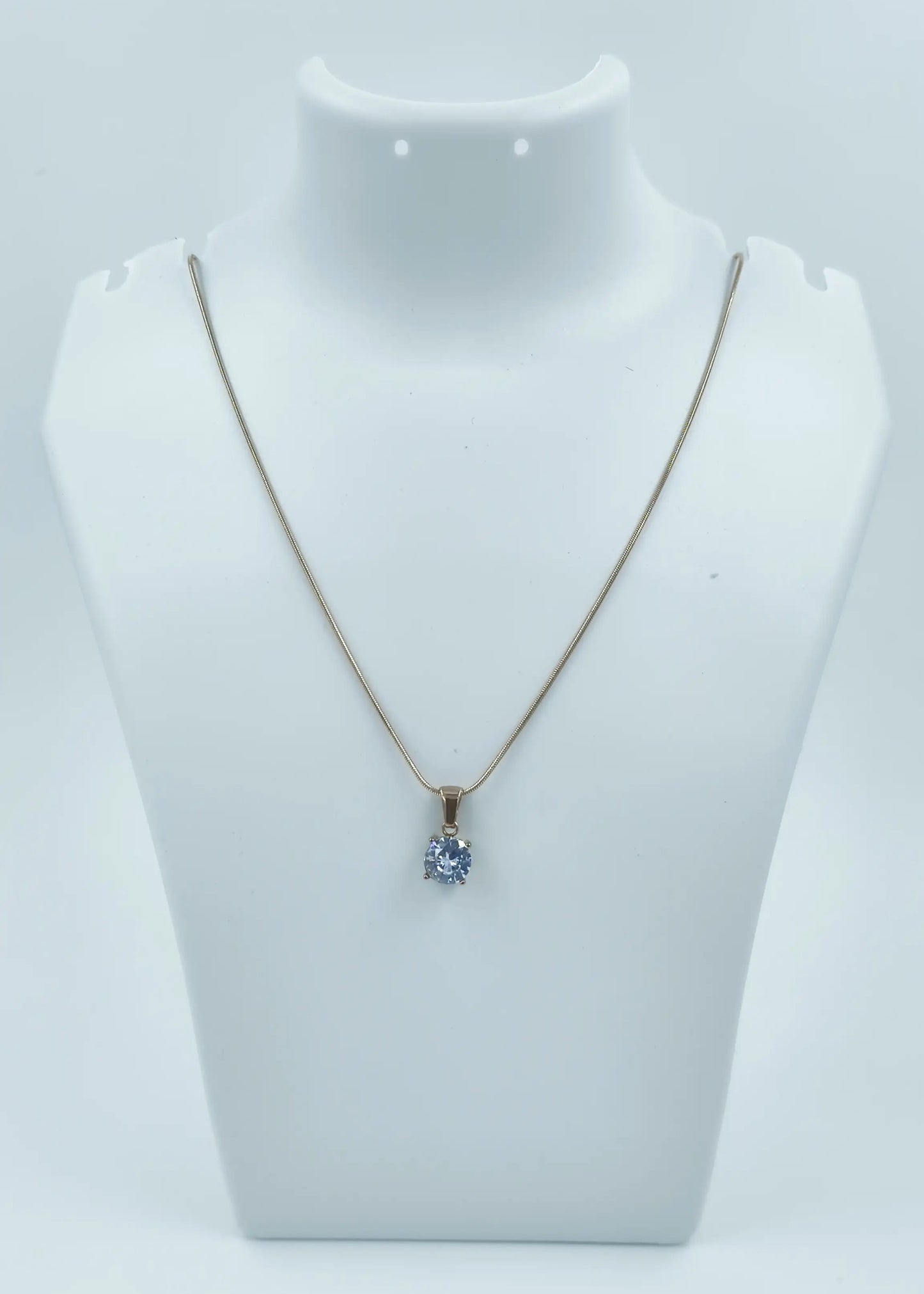 Necklace with a pendant on a mannequin bust against a white background