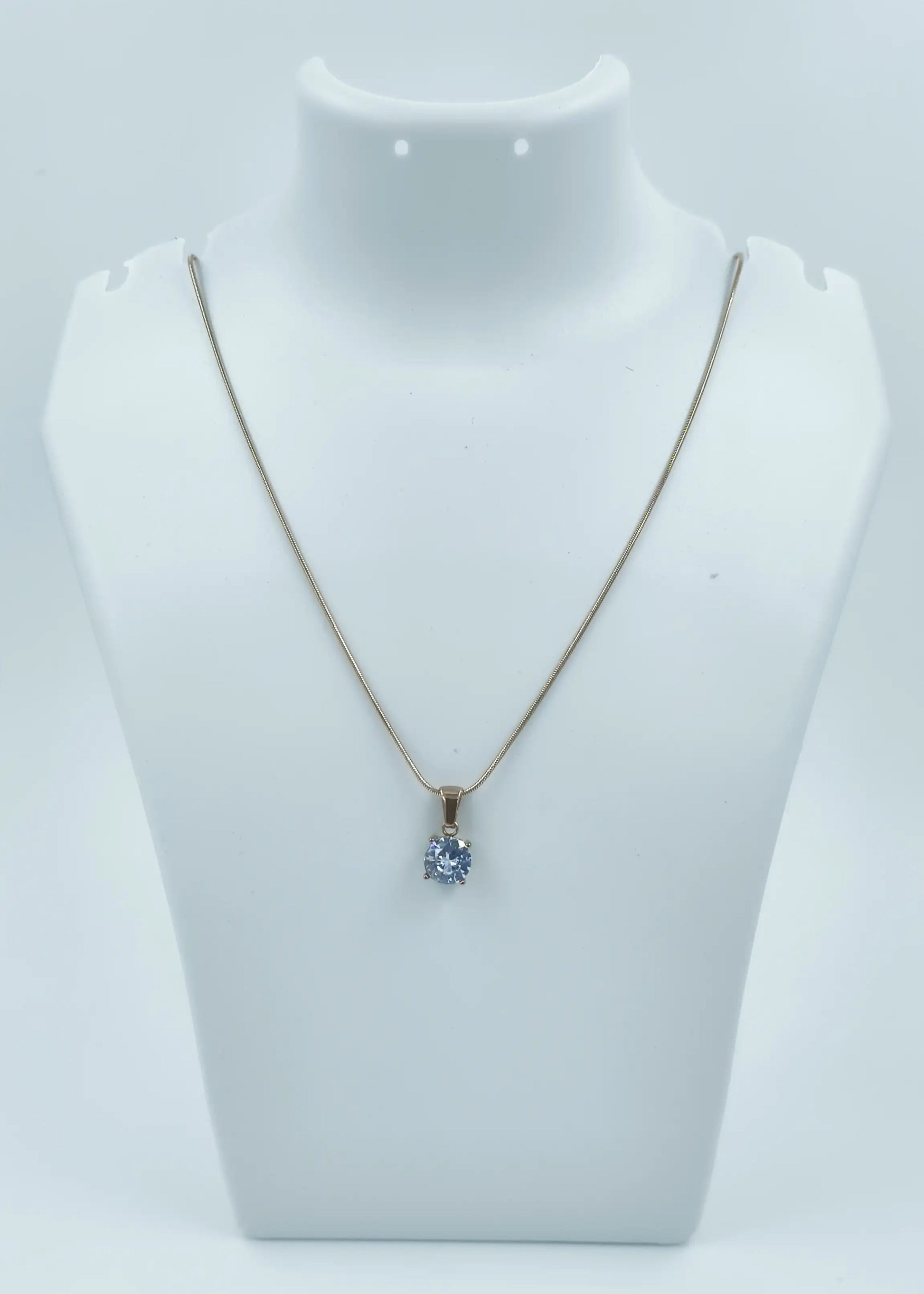 Necklace with a pendant on a mannequin bust against a white background