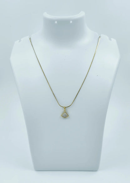 Gold necklace with a pendant on a mannequin bust against a white background