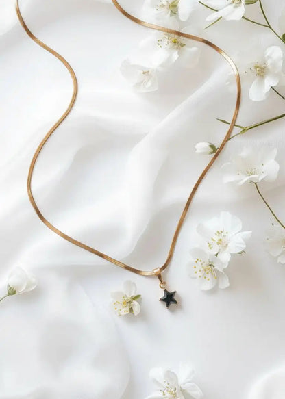 Gold necklace with a star pendant on a white fabric background