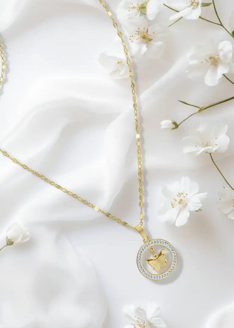 Gold necklace with a heart pendant on a white fabric background