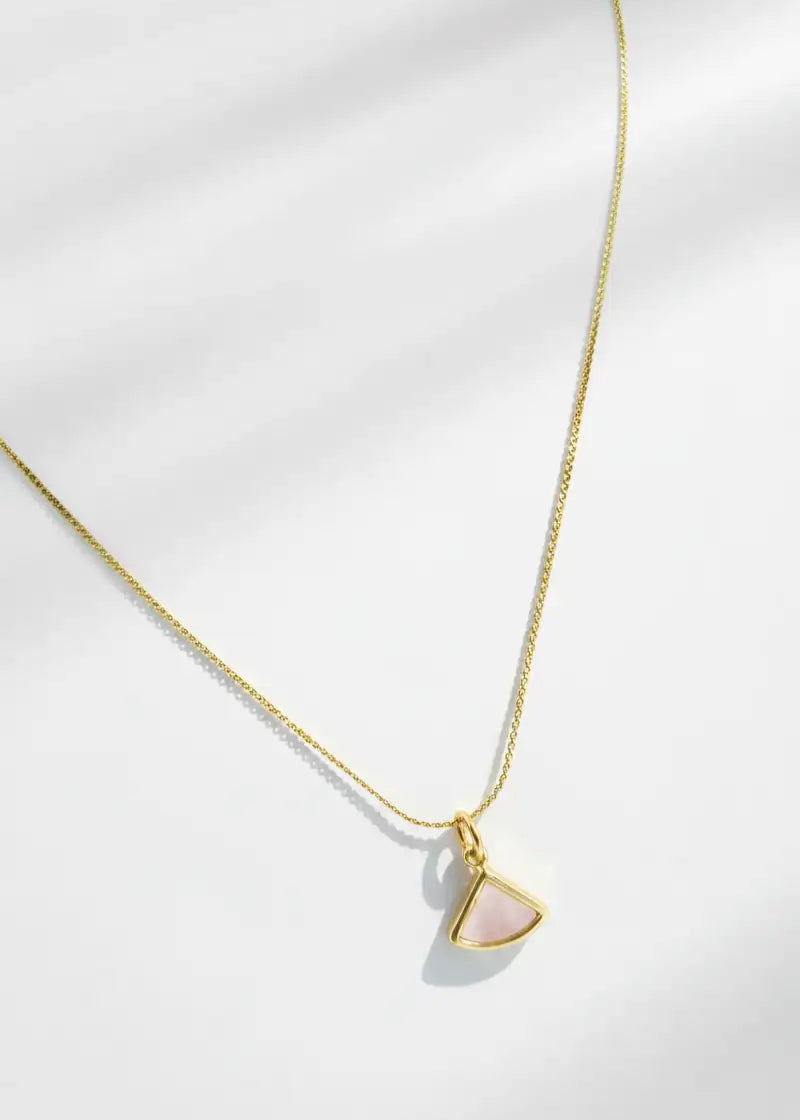 Gold necklace with a triangular pendant on a white background
